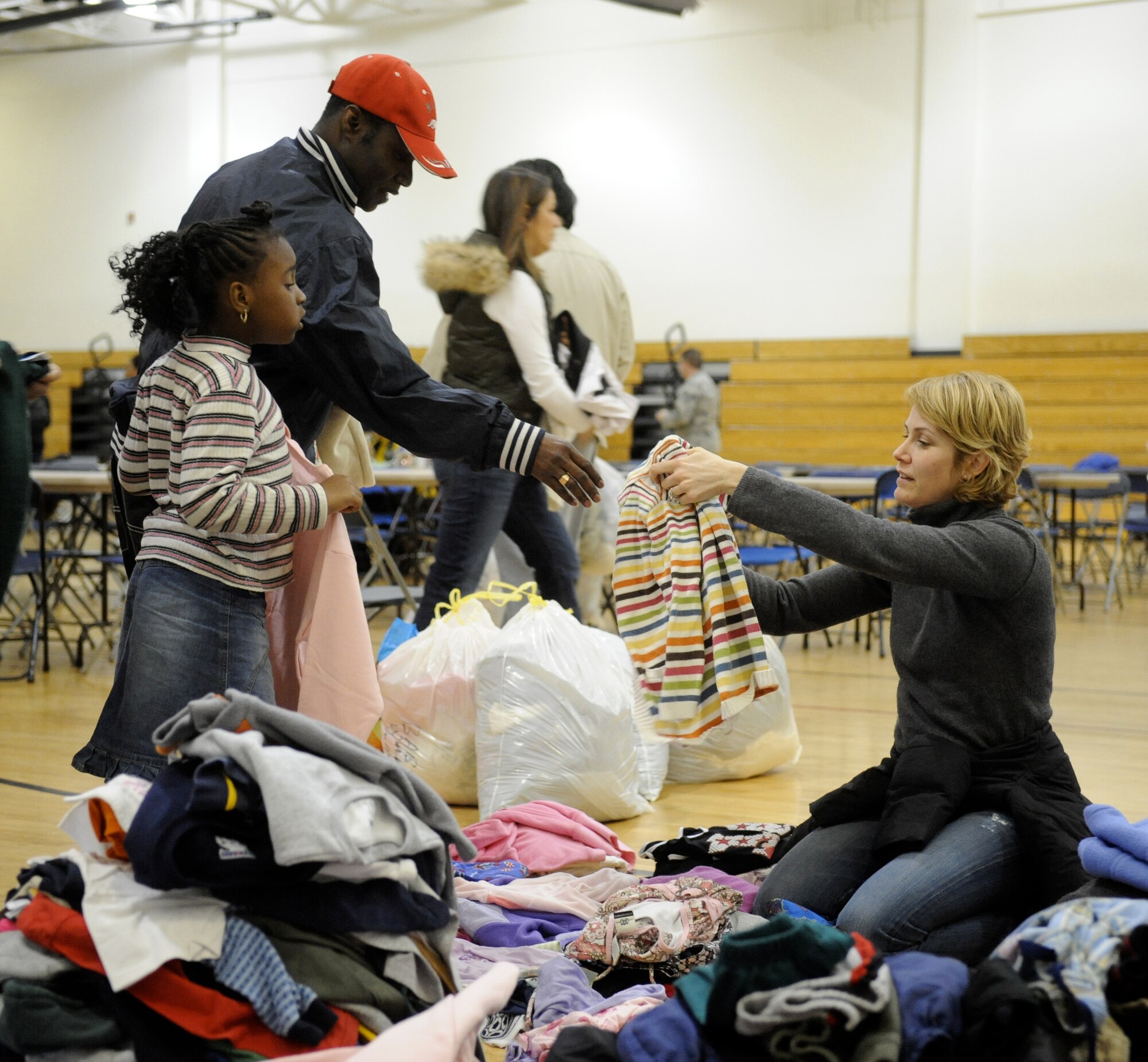 JOINT BASE MCGUIRE-DIX-LAKEHURST, N.J. -- Jana Finch, wife of Lt. Col. Mike Finch 305th Operations Squadron, volunteered to help hand out warm clothes to evacuees at a temporary shelter at the McGuire fitness Center Jan 15. The shelter is equipped to provide food, water, medical care, and phones for calling relatives and setting up travel arrangements.  (U.S. Air Force photo Carlos Cintron)
