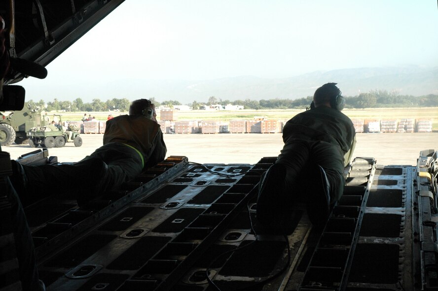 PORT-AU-PRINCE, Haiti -- Two 317th Airlift Group Airmen lie on the back of a C-130 Hercules while stopped at the Port-au-Prince Toussaint Louverture International Airport in Haiti Jan. 19. The C-130 crew of six departed Dyess Air Force Base to support relief efforts following the 7.0-magnitude earthquake that devistated the Caribbean nation Jan. 14. The Air Force's airlift capability enables the United States to respond immediately to any disaster domestically or worldwide. We are the only country with an aircraft fleet capable of providing this type of response. (U.S. Air Force photo/ Tech. Sgt. Robert Wollenberg)

