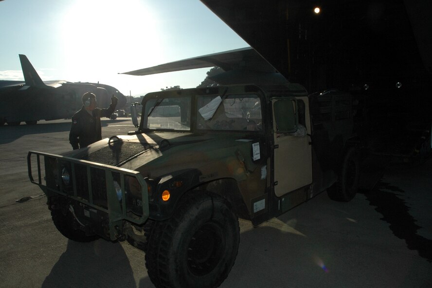 PORT-AU-PRINCE, Haiti -- A Highly Mobility Multipurpose Wheeled Vehicle is driven from the back of a C-130 Hercules while stopped at the Port-au-Prince Toussaint Louverture International Airport in Haiti Jan. 19. The C-130 crew of six departed Dyess Air Force Base to support relief efforts following the 7.0-magnitude earthquake that devistated the Caribbean nation Jan. 14. The Air Force's airlift capability enables the United States to respond immediately to any disaster domestically or worldwide. We are the only country with an aircraft fleet capable of providing this type of response. (U.S. Air Force photo/ Airman 1st Class Robert Hicks) 