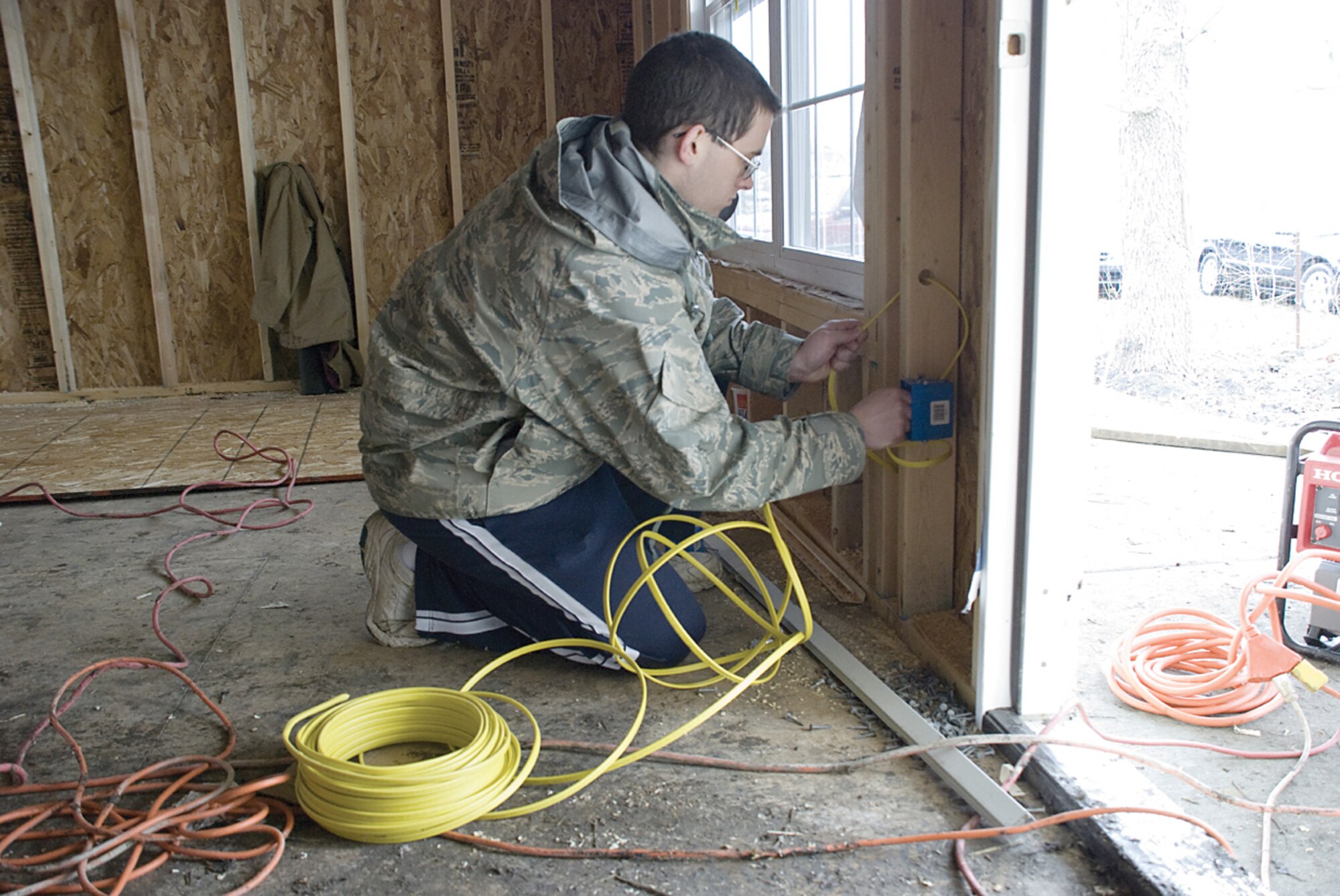 COLLINSVILLE, Ill. -- Retired Senior Master Sgt. Dave Zimmerer works with an electrical switch Saturday at a Habitat for Humanity house being constructed in State Park Place near Collinsville, Ill.  Volunteers from Scott have been working on the house since fall 2009. (U.S. Air Force photo/ Steve Berry)