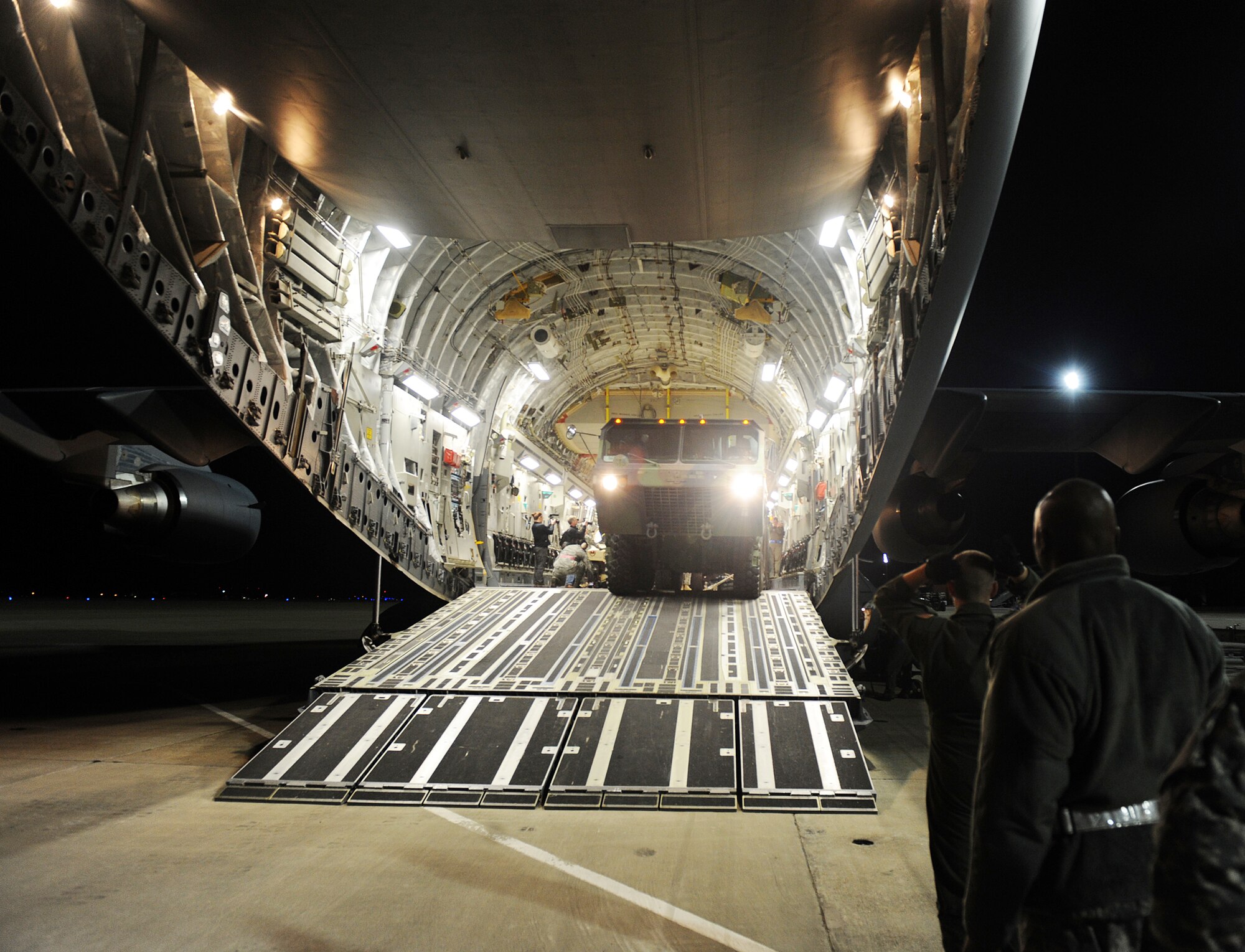 An M1120 Heavy Expanded Mobility Tactical Truck Load Handling System backs into a C-17 Globemaster III from the 512th Airlift Wing, Dover Air Force Base, Del. Jan. 19, 2010, at Langley Air Force Base, Va. Personnel from Langley AFB and Fort Eustis, Va., worked together to load the C-17 as part Operation Unified Response. (U.S. Air Force photo/Senior Airman Zachary Wolf) 
