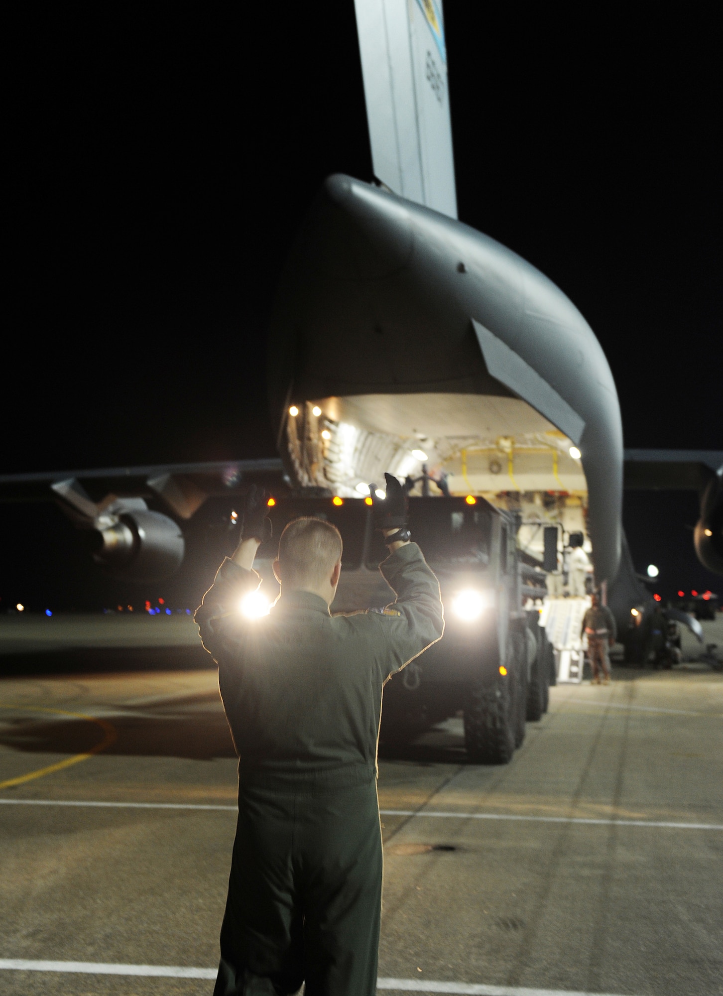 A loadmaster directs an M1120 Heavy Expanded Mobility Tactical Truck Load Handling System into a C-17 Globemaster III Jan. 19, 2010, at Langley AIr Force Base, Va. Personnel from Langley AFB and Fort Eustis, Va., worked together to load the C-17 as part Operation Unified Response. The loadmaster is assigned to the 512th Airlift Wing at Dover Air Force Base, Del. (U.S. Air Force photo/Senior Airman Zachary Wolf) 