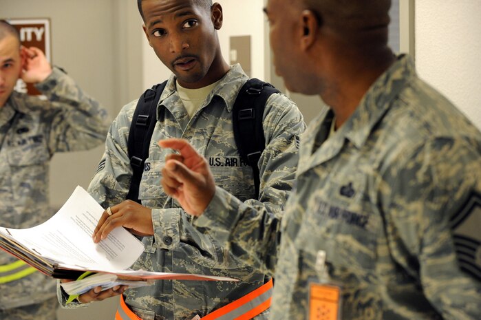 NELLIS AIR FORCE BASE, Nev.-- Senior Airman Quinton Jones of the 99th Communications Squadron answers questions about how to access his training records from a 99th Air Base Wing, Exercise Evaluation team member while processing the line at the deployment center as part of an operational readiness exercise Jan. 19. The ORE is in preparation for an upcoming operation readiness inspection Jan. 25-29. (U.S. Air Force photo by Tech. Sgt. Michael R. Holzworth)