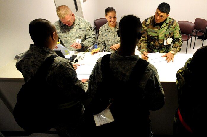 NELLIS AIR FORCE BASE, Nev.-- Staff Sgt. Jacob Taylor, Senior Airman Andrea Fish, and Senior Airman Cecil Lizana of 99th Aerospace Medicine Squadron complete the pre-deployment medical screening at the deployment center as part of a 99th Air Base Wing operational readiness exercise Jan. 19. The ORE is in preparation for an upcoming operation readiness inspection Jan. 25-29.  (U.S. Air Force photo by Tech. Sgt. Michael R. Holzworth)