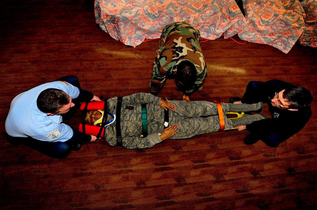 ELLSWORTH AIR FORCE BASE, S.D. -- (Left to right) Scott Van Drew, Senior Airman O'Brian Thomas and Bill Beck, 28th Civil Engineer Squadron firefighters, prepare to lift a "victim" during an Emergency Medical Technician training session, Jan. 19. As part of a requirement set by the National Registry of Emergency Medical Technicians, firefighters must validate their EMT skills every two years. (U.S. Air Force photo/Airman 1st Class Joshua J. Seybert)