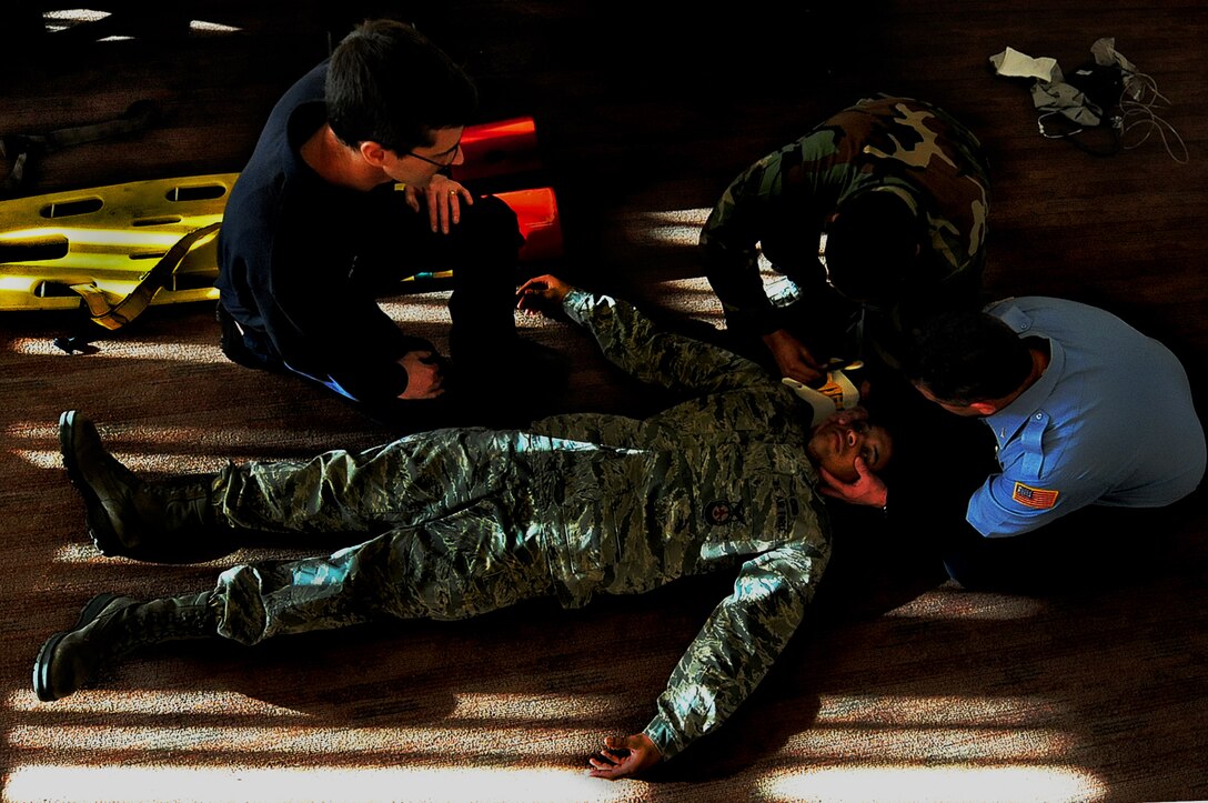ELLSWORTH AIR FORCE BASE, S.D. -- (Left to right) Bill Beck, Senior Airman O'Brian Thomas and Scott Van Drew, 28th Civil Engineer Squadron firefighters, check a "victim" for injuries during an Emergency Medical Technician training session, Jan. 19. Firefighters must validate their EMT skills every two years as part of a requirement set by the National Registry of Emergency Medical Technicians. (U.S. Air Force photo/Airman 1st Class Joshua J. Seybert)