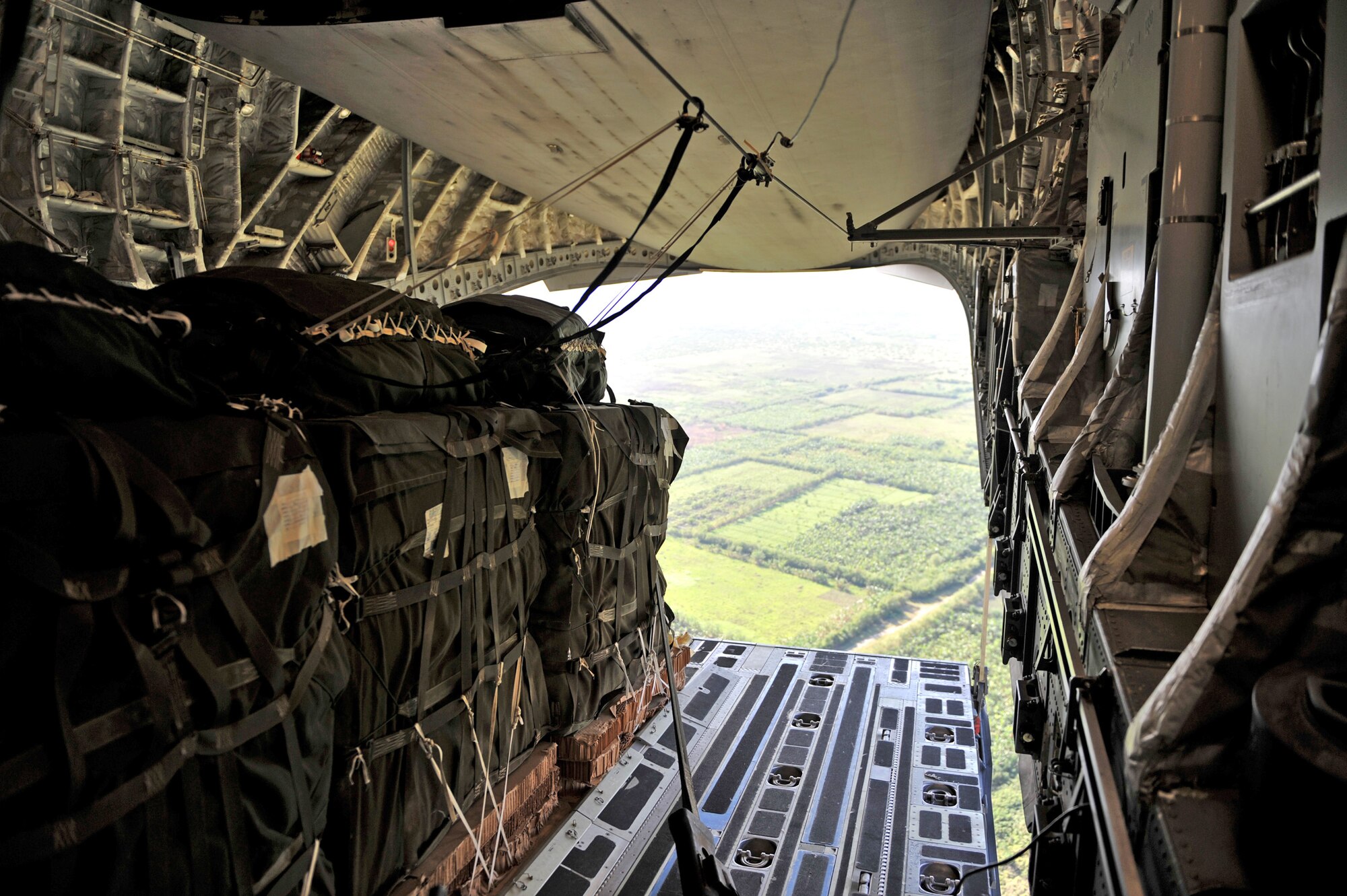 Pallets of relief supplies exit a C-17 Globemaster III cargo aircraft over Haiti Jan. 18, 2010. The C-17, crewed by Airmen from the 437th Airlift Wing at Charleston Air Force Base, S.C., departed Pope AFB, N.C., and delivered 40 pallets of food and water into Haiti. Joint Task Force-Haiti secured the area where the supplies were delivered. Once on the ground, supplies were distributed by JTF-Haiti, the U.S. Agency for International Development and other relief personnel. (U.S. Air Force photo/Master Sgt. Shane A. Cuomo)