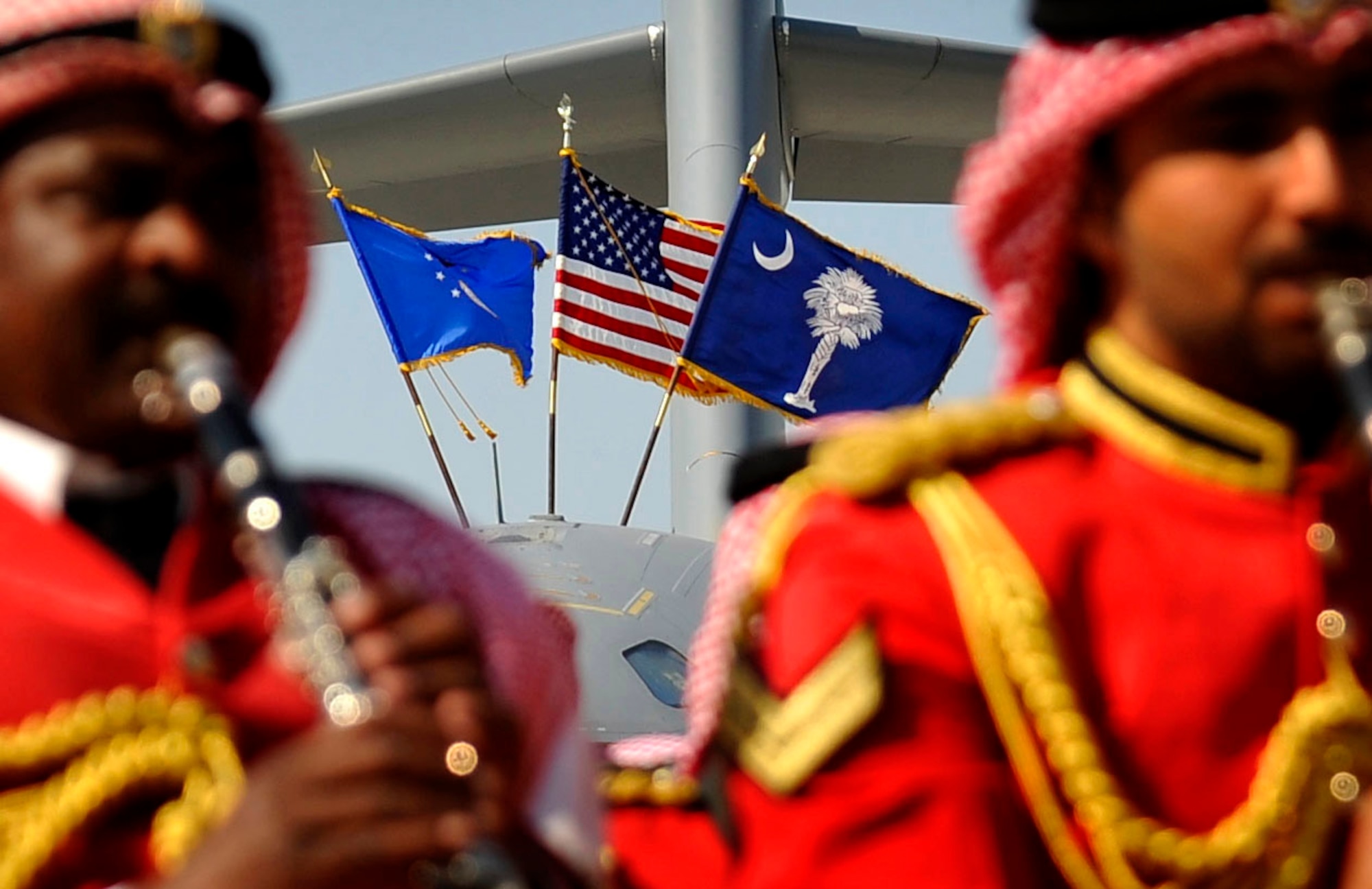 The U.S. flag, along with the Air Force and South Carolina state flag fly in the breeze while a Bahraini military band plays Jan. 21, 2010, at the Bahrain International Airshow.  (U.S. Air Force photo/ SSgt Angelita Lawrence/released)