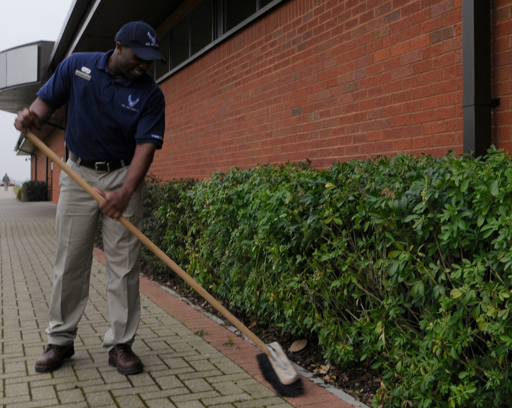 RAF MILDENHALL, England -- Senior Airman Lafayette Workman, 100th Force Support Squadron, cleans up the area around the Hardstand Fitness center Jan. 21.  After weeks of snow and wet weather, members of Team Mildenhall have started to clean up the mud, sand and dead leaves littering the base.  (U.S. Air Force photo/Staff Sgt. Christopher L. Ingersoll)