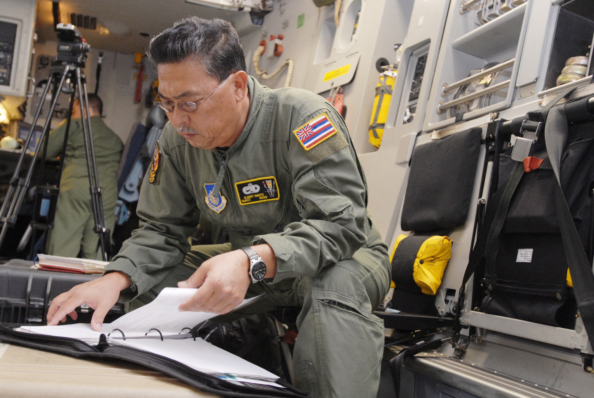 Senior Master Sgt. Elbert Emoto, a member of the Hawaii Air National Guard, reviews C-17 Globemaster III maintenance records before a flight Jan. 19, 2010, at Hickam Air Force Base, Hawaii.  The C-17 and crew are flying to Charelston AFB, S.C. to take part in ongoing humanitarian airlift operations to Haiti. (U.S. Air Force photo/ Staff Sgt. Michael Meares)