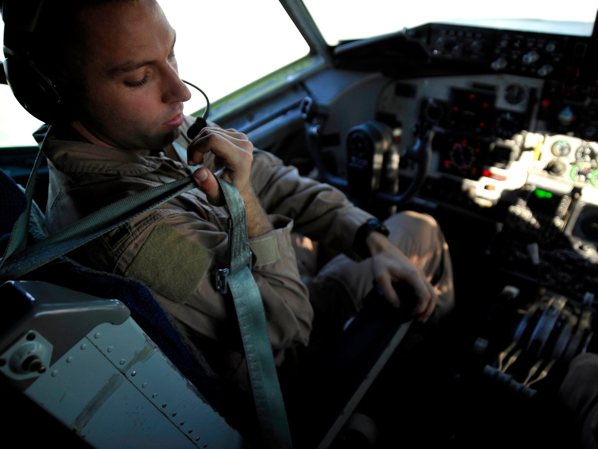 U.S. Air Force Capt. Brandon Gillet, 340th Expeditionary Air Refueling Squadron KC-135 Stratotanker pilot, puts on his seatbelt before starting engines, Jan.15, 2010, in Southwest Asia.  The KC-135 will be refueling aircraft over Afgahanistan to support Operation Enduring Freedom. (U.S. Air Force photo/ SSgt Angelita Lawrence/released)
