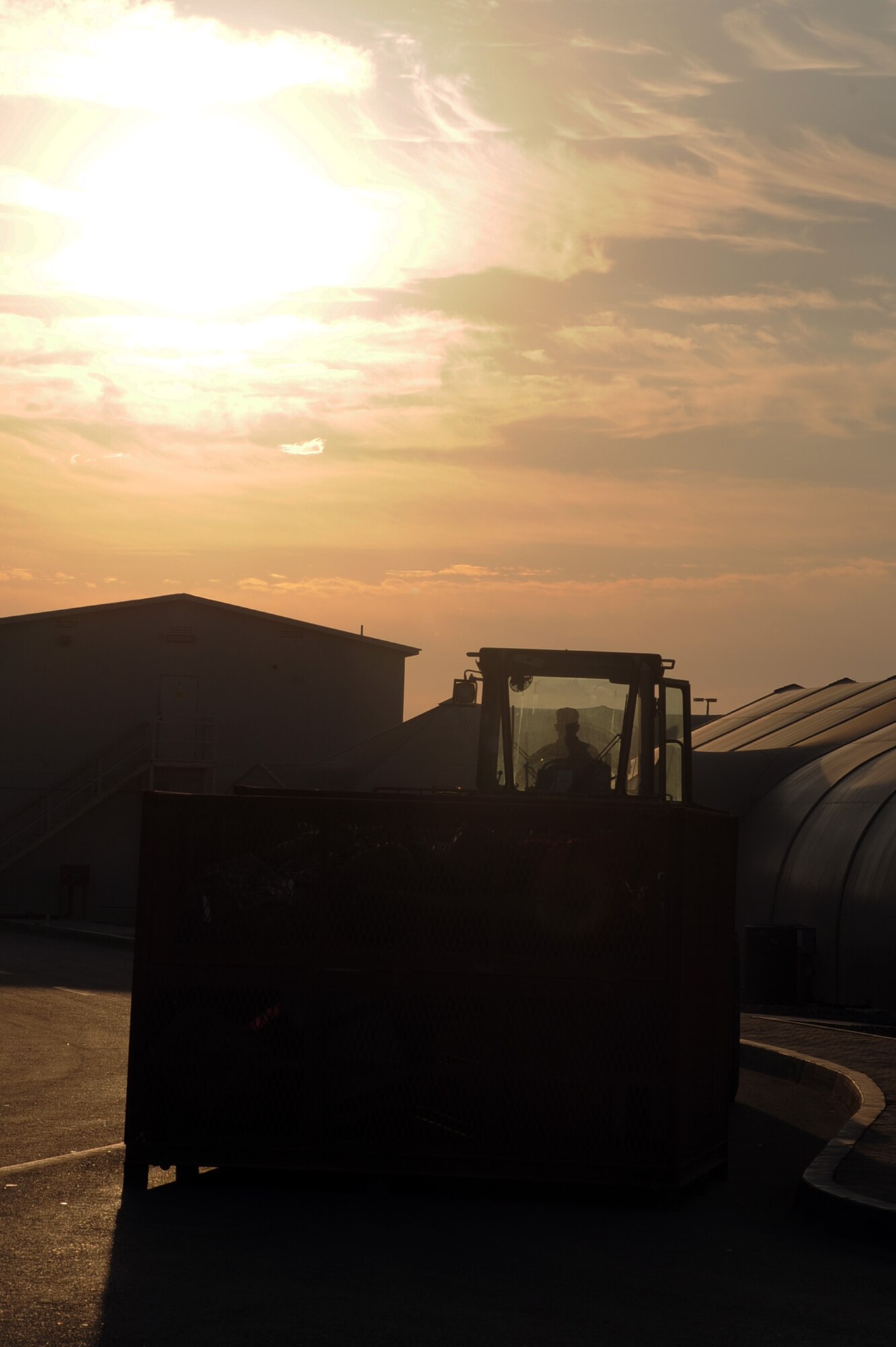 An air transportation Airman from the 380th Expeditionary Logistics Readiness Squadron uses an extreme terrain forklift to move some cargo bins in the camp of the 380th Air Expeditionary Wing during sunrise hours Jan. 21, 2010. The 380th Air Expeditionary Wing supports Operations Iraqi Freedom and Enduring Freedom and the Combined Joint Task Force-Horn of Africa. (U.S. Air Force Photo/Tech. Sgt. Scott T. Sturkol/Released)
