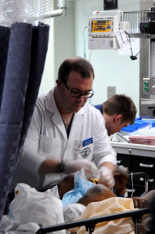 USNS Comfort Cmdr. Timothy Donahue treats a Haitian medical patient in the casualty receiving area of the hospital ship, Port-Au-Prince, Haiti, Jan, 20, 2010. Comfort arrived off the coast of Port-Au-Prince yesterday and began treating patients in support of Operation Unified Response: Haiti. Comfort will provide afloat, mobile and acute surgical medical facilities to treat Haitian medical patients.