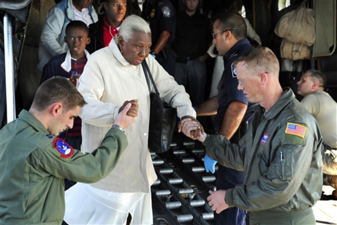 U.S. Air Force Capt. Philip Noland, left, and Tech. Sgt. Brian Ghent help an elderly Haitian earthquake survivor down the ramp of a U.S. Air Force C-130 Hercules aircraft at Homestead Air Reserve Base, Fla., Jan. 20, 2010. Since a devastating earthquake struck Haiti, the base has become a major hub for evacuees seeking aid.