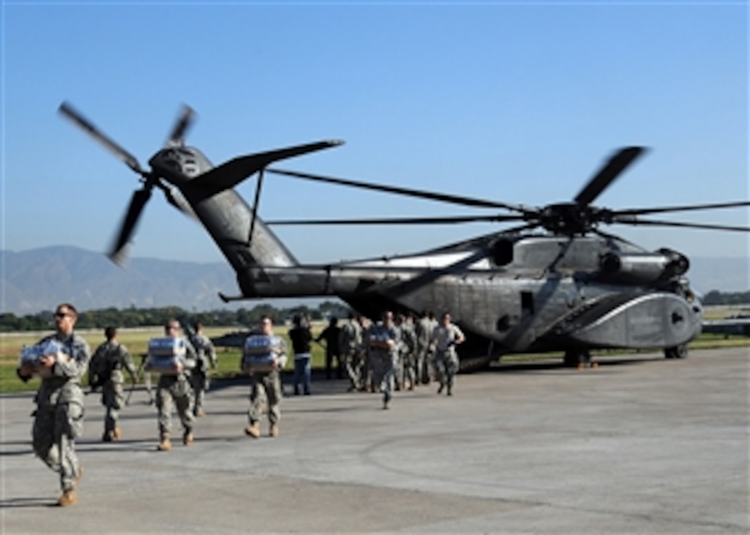 U.S. Army soldiers unload food and supplies from a Navy MH-53E Sea Dragon helicopter from the aircraft carrier USS Carl Vinson (CVN 70) at the airport in Port-au-Prince, Haiti, on Jan. 15, 2010.  The U.S. military is conducting humanitarian and disaster relief operations after a 7.0-magnitude earthquake caused severe damage in and around Port-au-Prince on Jan. 12, 2010.  
