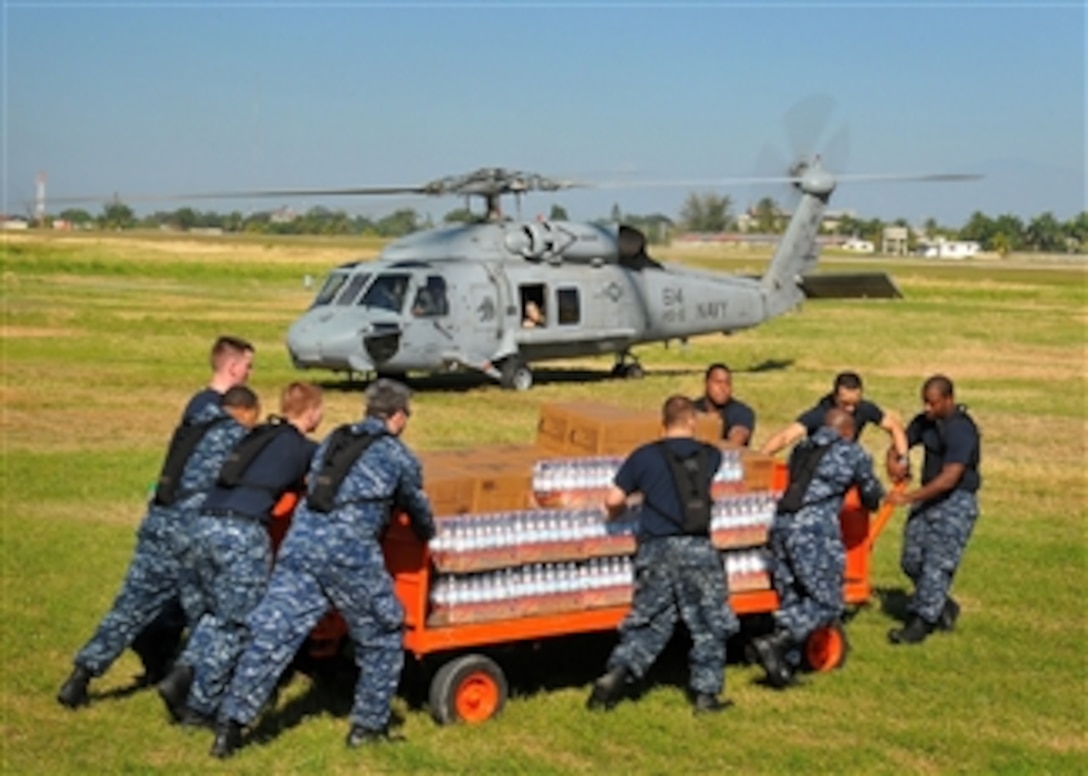 U.S. Navy sailors from the aircraft carrier USS Carl Vinson (CVN 70) load water into an SH-60F Seahawk helicopter during humanitarian relief efforts in Port-au-Prince, Haiti, on Jan. 18, 2010.  The ship and Carrier Air Wing 17 are conducting humanitarian and disaster relief operations as part of Operation Unified Response after a 7.0-magnitude earthquake caused severe damage in and around Port-au-Prince on Jan. 12, 2010.  