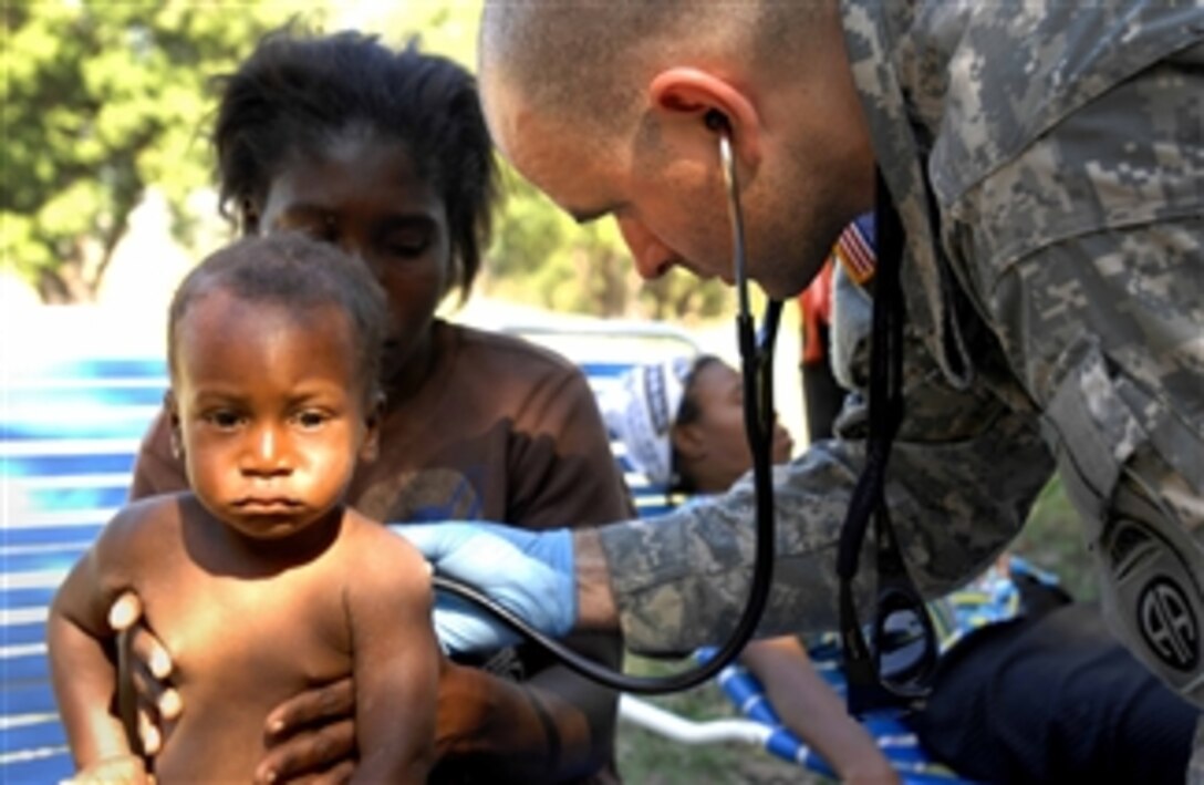 U.S. Army Capt. Mark Poirier, a medical officer with the 1st Squadron, 73rd Cavalry Regiment, 2nd Brigade Combat Team, 82nd Airborne Division, checks a baby brought to the squadron's forward operating base in Port-au-Prince, Haiti, on Jan. 18, 2010.  