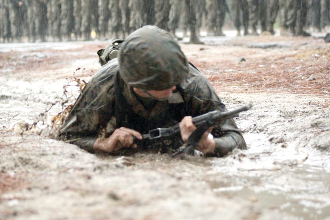 Rct. Steven Campbell, a recruit with Plt. 1008 Bravo Co., 1st RTBn., crawls through mud as he begins the day movement course of BWT.