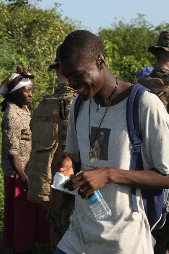 A Haitian from Cotes De Fer, grins after receiving a nutrition bar and water from Marines with the 22nd Marine Expeditionary Unit, Jan. 21, 2010.  Marines and sailors from the 22nd MEU set up a temporary relief-supply distribution point near Cotes de Fer, bringing in bottled water and food.  The 22nd MEU, embarked aboard the ships of the Bataan Amphibious Ready Group, is deployed in support of relief operations in Haiti.  (Official Marine Corps photo by Staff Sgt. Wayne Campbell)::r::::n::