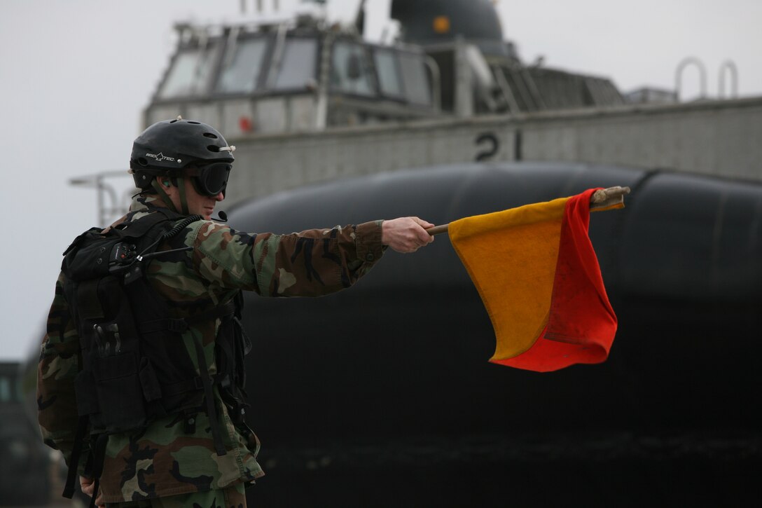 Petty Officer 3rd Class Andrew Saslow, a beachmaster with the forward-deployed Essex Amphibious Ready Group (ARG), directs a landing craft air cushion (LCAC) safely ashore, Jan. 22. More than 170 vehicles and 450 tons of equipment from the 31st Marine Expeditionary Unit (MEU) were embarked aboard the forward-deployed Essex ARG in support of the Spring Patrol. The MEU’s first scheduled exercise is Cobra Gold 2010 (CG’ 10).  CG’ 10 is the latest in a continuing series of exercises designed to promote regional peace and security.