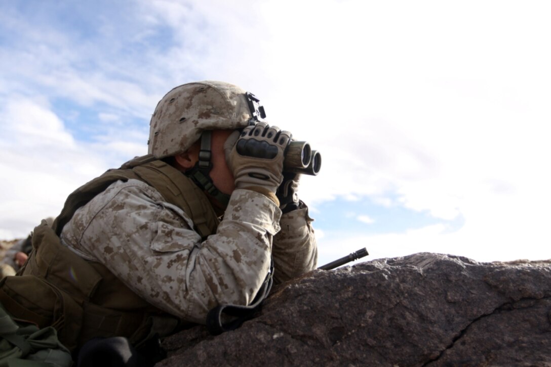 Lance Cpl. Naylan Grady, a rifleman with Weapons Company, 1st Battalion, 7th Marine Regiment, observes enemy role player activity during a Combat Hunter Course exercise at Combat Center Range 200 here Jan. 22.