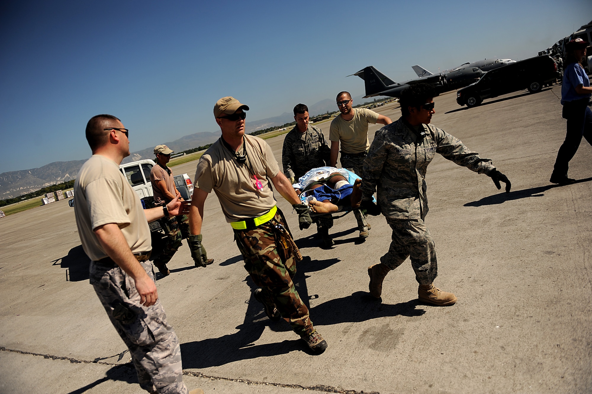 Medics from the 1st Special Operations Support Squadron carry an injured Haitian man at Troussaint L’Ouverture International Airport in Port-au-Prince, Haiti, Jan. 18. Both Airmen are medics in Haiti as part of the U.S. respone to the 7.0 magnitude earthquake that struck the country Jan. 12. (U.S. Air Force photo by Master Sgt. Jeremy Lock/Released)