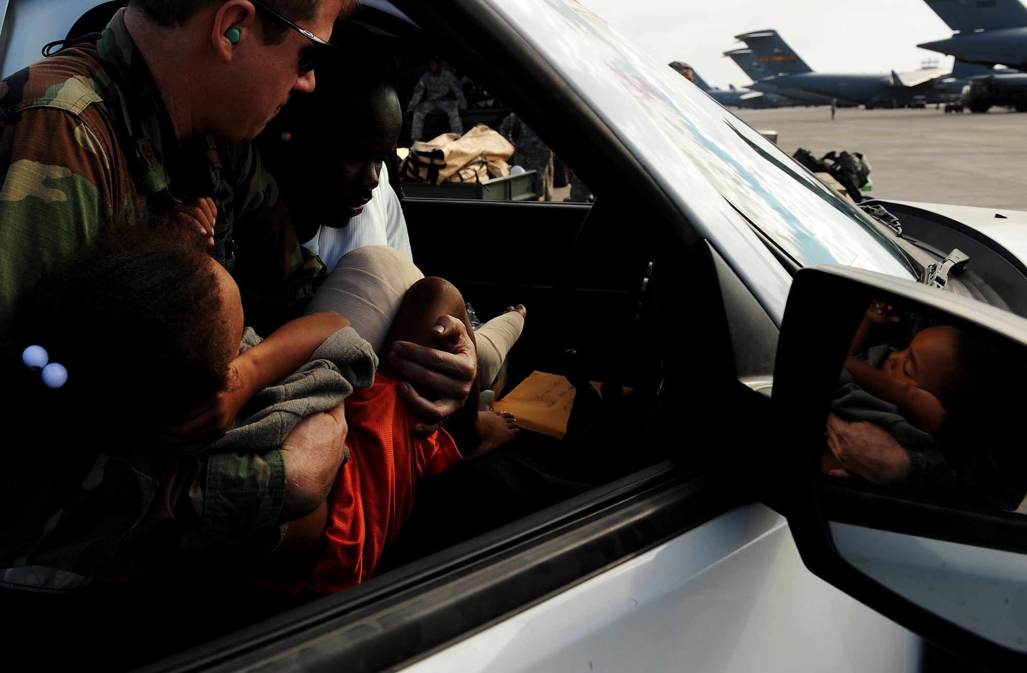 A doctor from the 1st Special Operations Support Squadron loads a 6-year-old Haitian boy into a vehicle for transport to a field clinic at Toussaint Louverture International Airport in Port-au-Prince, Haiti, Jan. 19 prior to being airlifted to a stateside hospital in southern Florida. U.S. Department of Defense assets have been deployed to assist in the Haiti relief effort following a magnitude-7 earthquake that hit Port-au-Prince Jan. 12. (U.S. Air Force photo by Tech. Sgt. James L. Harper Jr./Released)