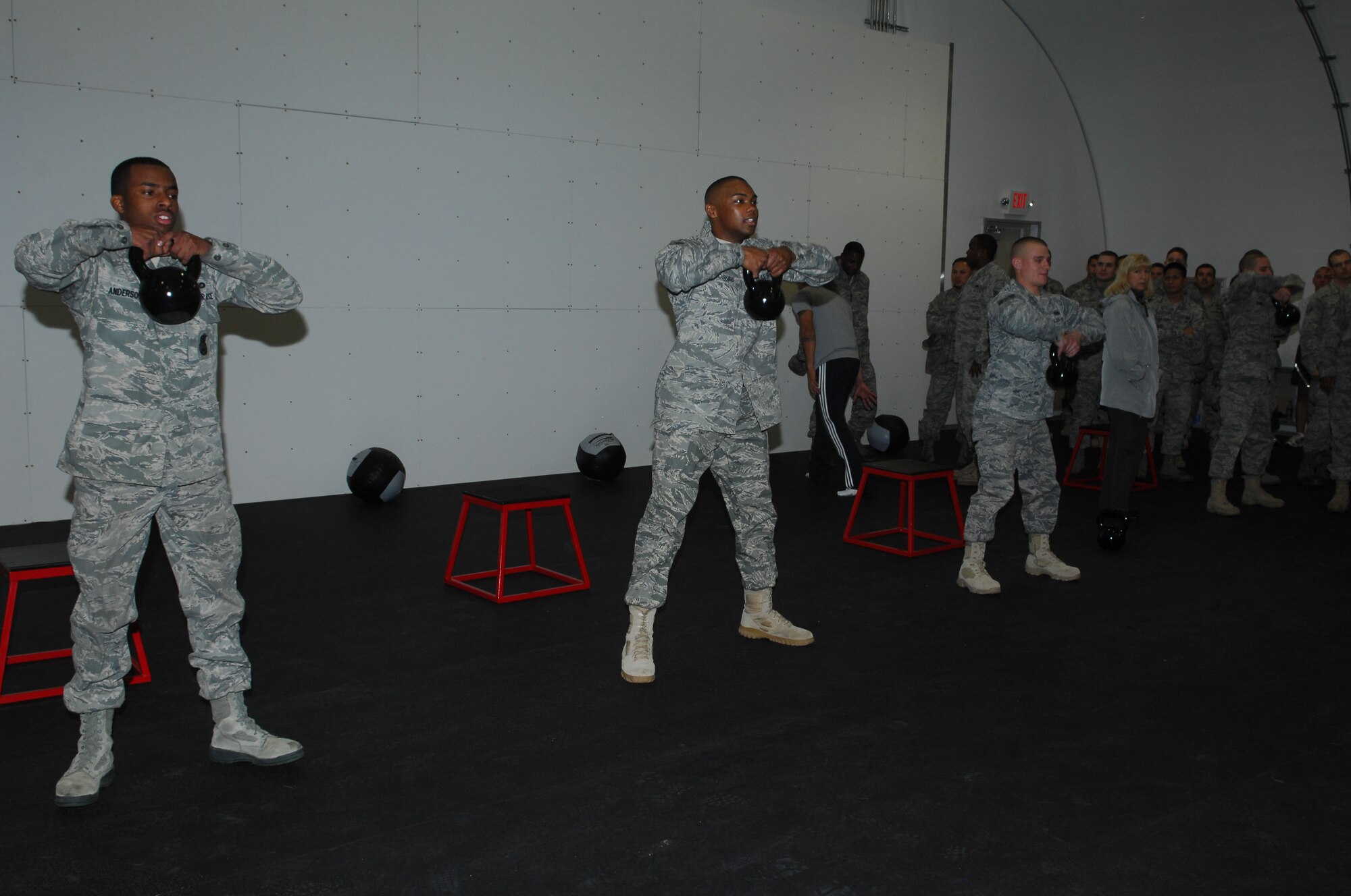 Airmen from the 56th Security Forces Squadron work out with kettlebells as part of a demonstration after the grand opening of the new Combat Physical Training center at Luke Air Force Base, AZ, Jan. 21. (Air Force photo/Staff Sgt. Steve Nabor)

