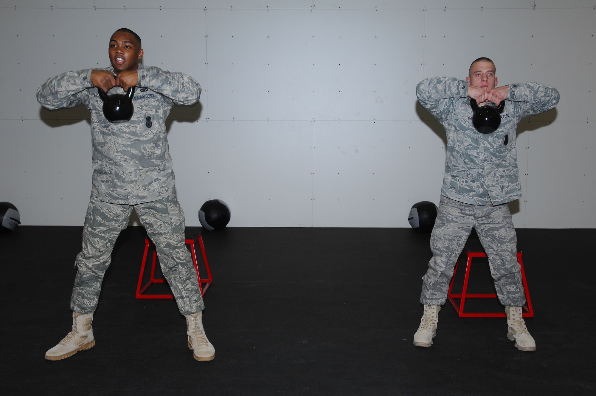 Senior Airmen Jeremy Card and Jose Hoskins from the 56th Security Forces Squadron, work out with kettlebells as part of a demonstration during the grand
opening of the new Combat Physical Training center at Luke Air Force Base, AZ, Jan. 21. (Air Force photo/Staff Sgt. Steve Nabor)
