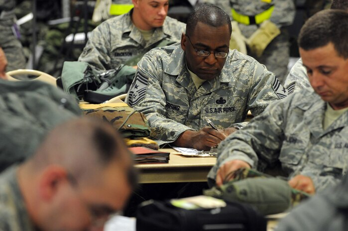 NELLIS AIR FORCE BASE, Nev.-- Chief Master Sgt. Alfred Herring, 99th Air Base Wing command chief inspects and inventories his cold weather gear while processing the line at the deployment center as part of a 99th Air Base Wing operational readiness exercise Jan. 19. The ORE is in preparation for an upcoming operation readiness inspection Jan. 25-29.  (U.S. Air Force photo by Tech. Sgt. Michael R. Holzworth)
