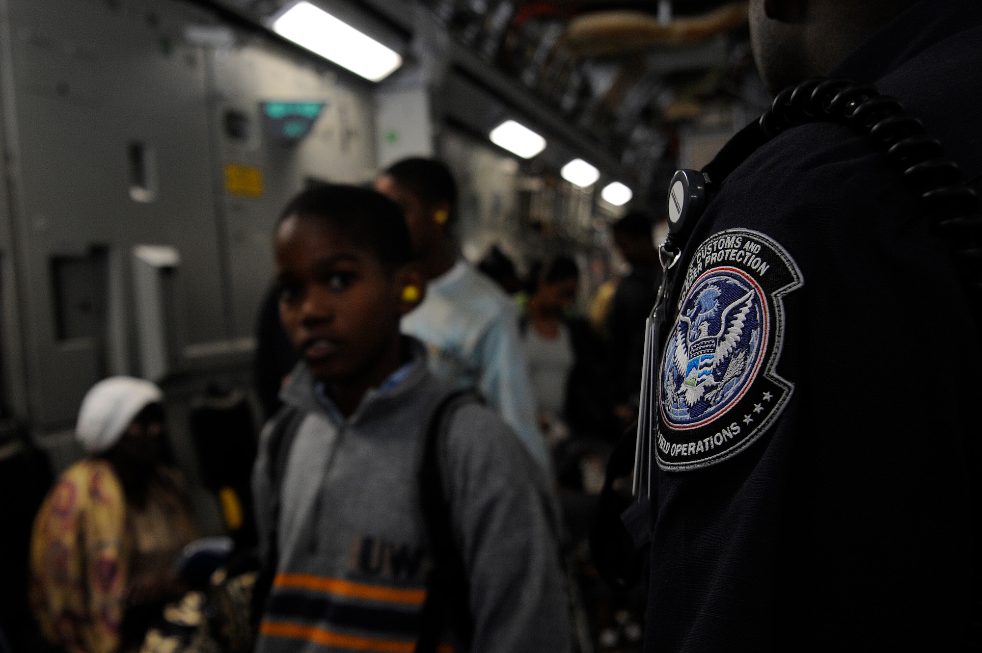 An evacuee from Haiti looks on as a U.S. Customs and Border Protection agent directs evacuees exiting a C-17 Globemaster III at Orlando Sanford International Airport Jan. 21. The C-17 carried more than 100 evacuees from Haiti after an earthquake devasted the country Jan.12, the evacuees consisted of both American and Haitian citizens.

(U.S. Air Force photo by Staff Sgt. Joseph L. Swafford Jr./Released)
