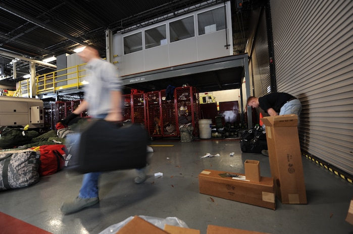 Senior Amn. Nicholas Torraco moves a protective case to a pallet while Staff Sgt. Chad James packs up a Self-Contained Breathing Apparatus into a protective case on Charleston AFB, Jan. 22. Airman Torraco is with a group of firefighters from different bases across the United States that are going to Haiti to support in the humanitarian relief effort. Both are firefighters, Airman Torraco is with McGuire AFB, N.J., and Sergeant James is with the Elmendorf AFB, Alaska, fire department. (U.S. Air Force photo/Senior Airman Katie Gieratz)(RELEASED) 