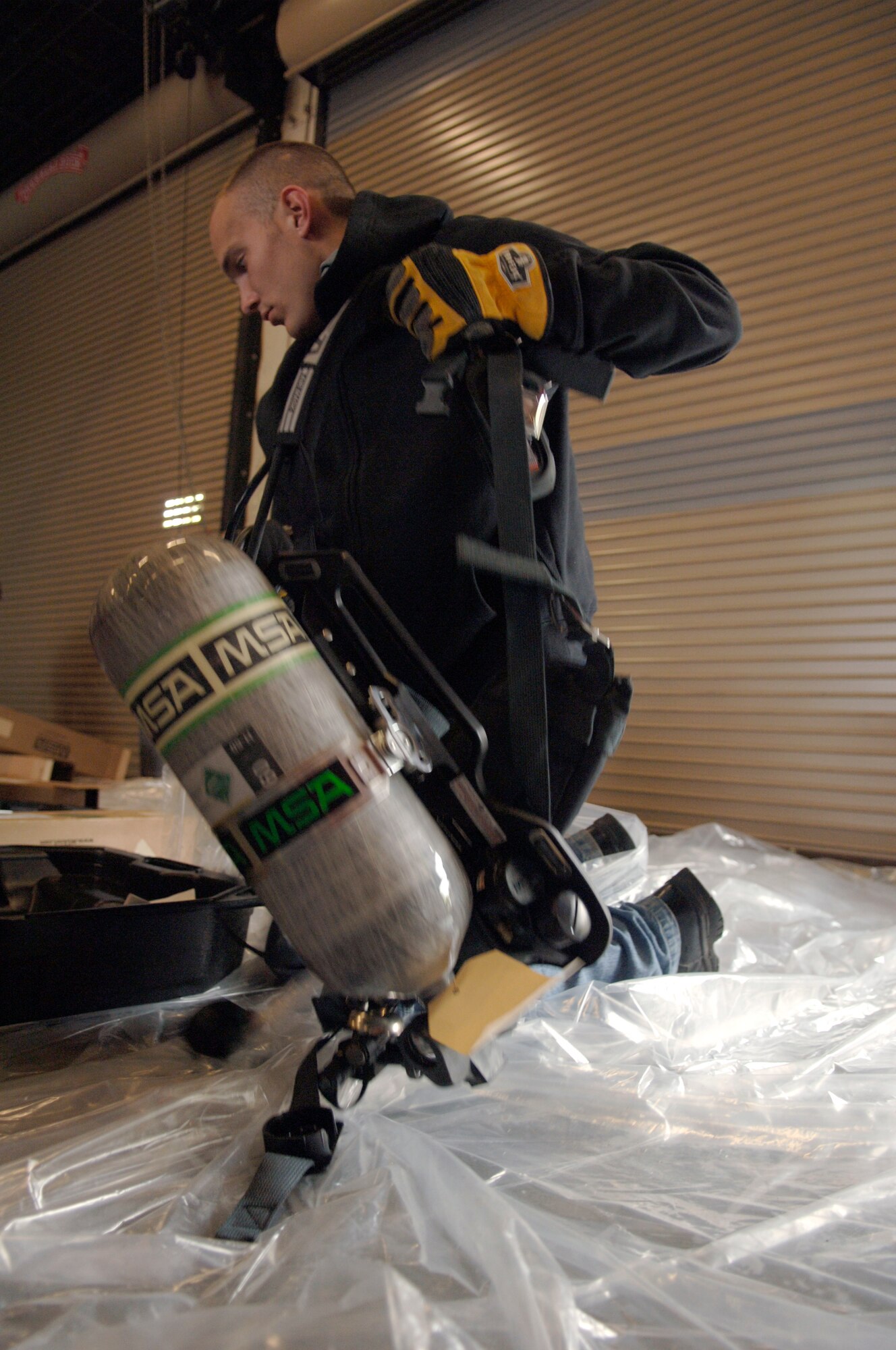 Senior Airman Zachary Wojcik  loads an air pack into a protective case to be moved onto a pallet bound for Haiti at Charleston AFB, Jan. 22. Airman Wojcik is one of many fire fighters from different bases around the United States that have come to assist with Haiti relief efforts. Airman Wojcik is fire fighter assigned to the 43rd Civil Engineer squadron with Pope AFB, N.C. (U.S. Air Force photo/Airman 1st Class Lauren Main)