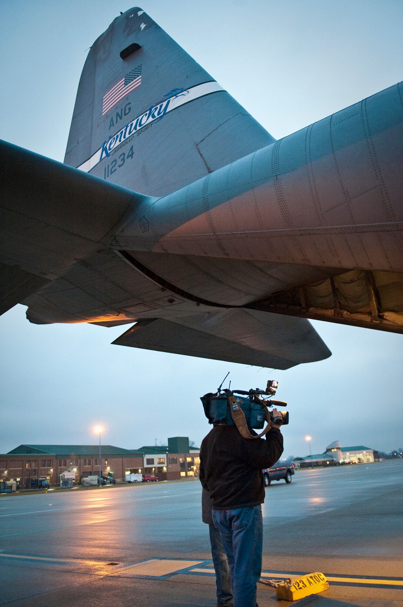 A member of the news media shoots video as the 123rd Airlift Wing prepares to load equipment and relief supplies onto a C-130 aircraft at the Kentucky Air National Guard Base in Louisville, Ky., on Jan. 22, 2010, for a flight to the Dominican Republic as part of earthquake relief efforts in Haiti. The flight was one of three C-130s that left from the unit today, along with approximately 45 Kentucky Air National Guardsmen. The troops are establishing an air cargo hub at Maria Montez International Airport that will be responsible for controlling incoming aircraft, offloading relief supplies and staging them for further movement into Haiti. (U.S. Air Force photo by Maj. Dale Greer)