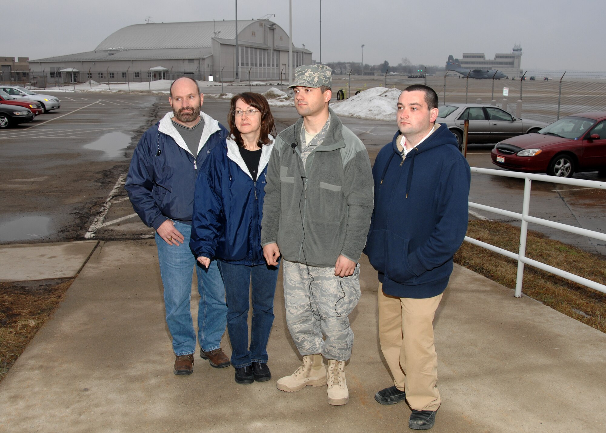 Airman First Class Sami Mofadi stands with Steve and Brenda Cox (left) and Trevor Cox (right) during an interview with local media before deploying for Southwest Asia. (U.S. Air Force photos by Ben Stasser)