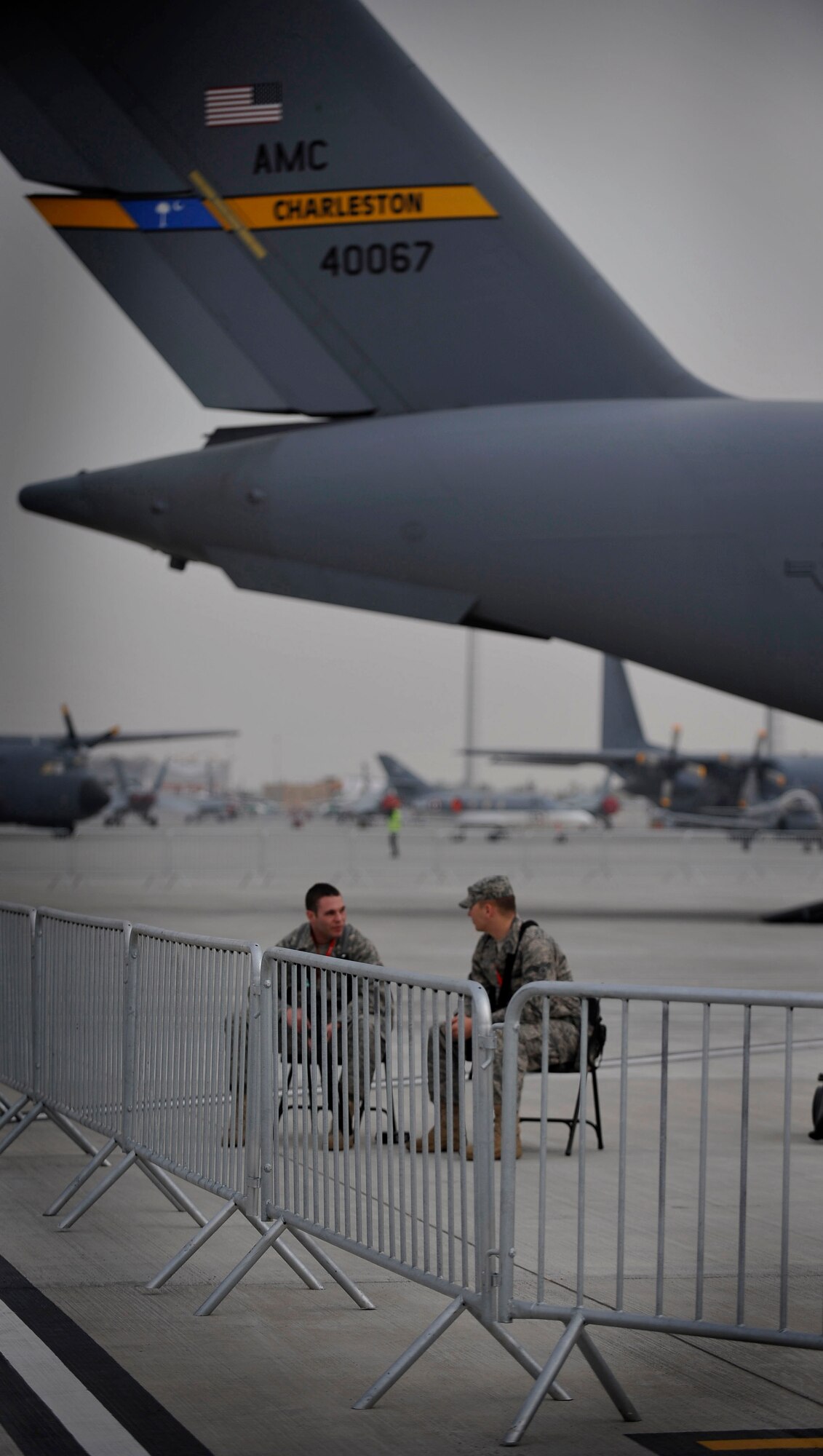 U.S. Air Force Airmen 1st Class Justin Murphy and Anthony Fox, from the 20th Security Forces Squadron at Shaw Air Force Base, S.C., take a seat while guarding aircraft during the inaguaral Bahrain International Airshow, Jan. 22, 2010. (U.S. Air Force photo/Staff Sgt. Angelita Lawrence/released)