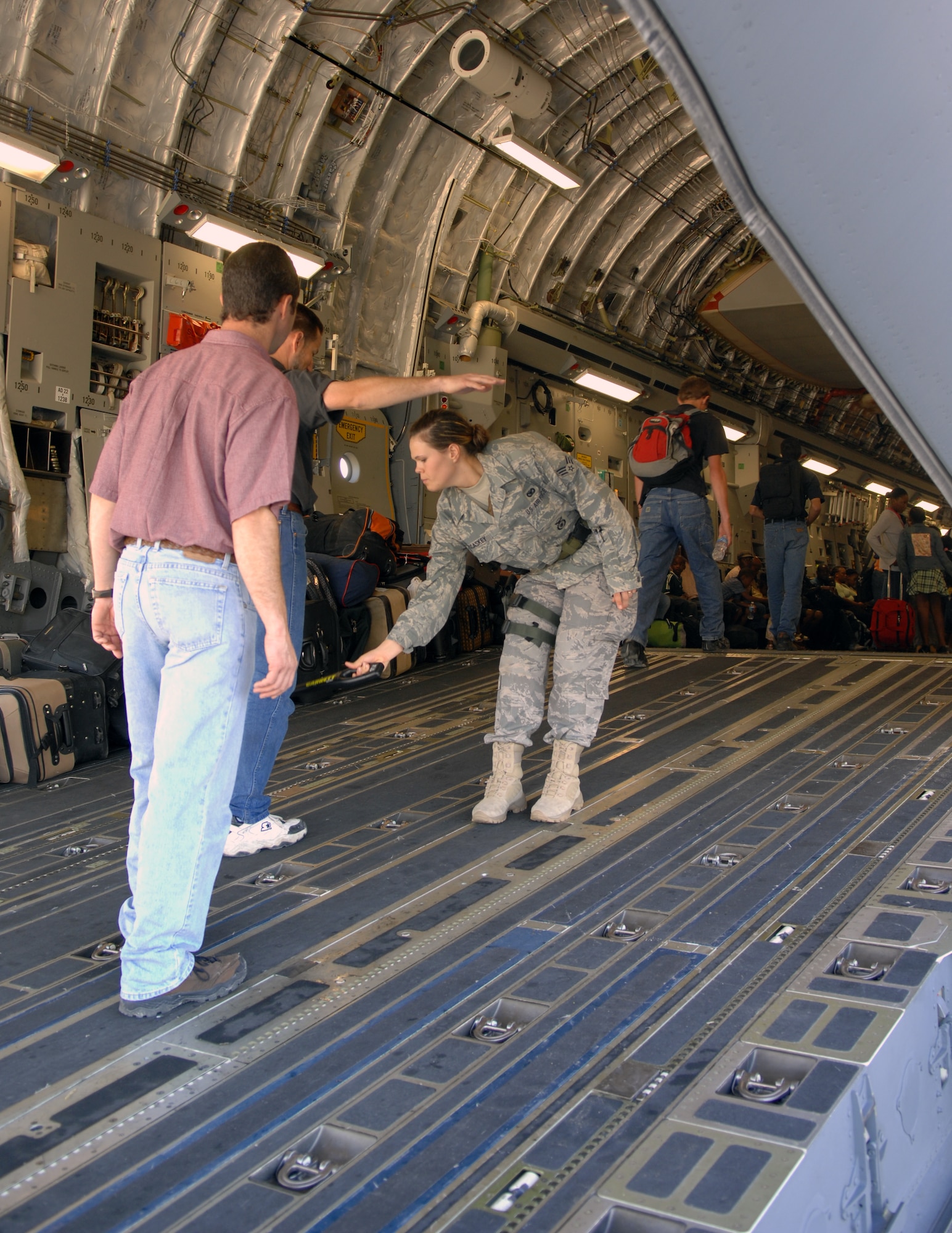 Senior Airman Rebecca McCaskey, 43rd Security Forces Squadron Raven, screens U.S. citizens boarding a C-17 cargo aircraft on the ramp at the Toussaint Louverture International Airport in Port-au-Prince, Haiti, Jan. 21, 2010.  Raven crews provide not only security in flight, but also during loading and unloading on the ground.   (U.S. Air Force photo/1st Lt. Matt Schroff)