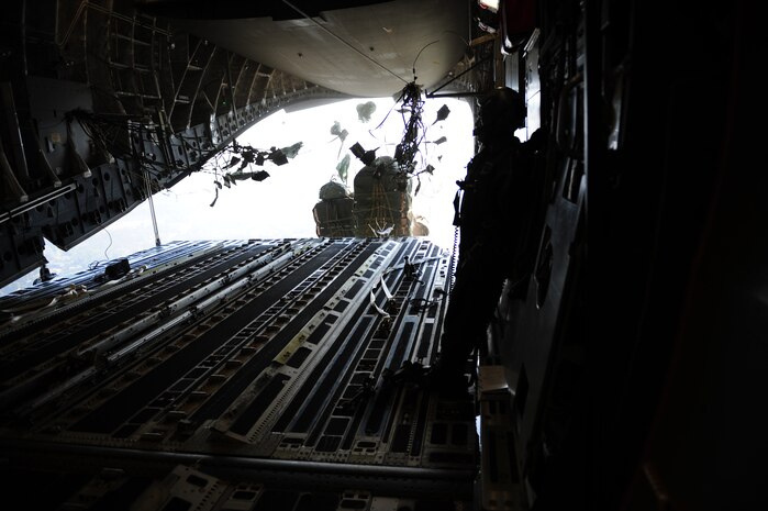 Container delivery system bundles exit a C-17 Globemaster III aircraft assigned to the 437th Airlift Wing, Charleston Air Force Base, S.C., during an air delivery mission over Haiti in support of Operation Unified Response Jan. 21, 2010. The aircrew, assigned to the 15th Airlift Squadron, Charleston AFB, S.C., delivered 40 container delivery system bundles totaling 67,800 pounds of Meals Ready to Eat and bottled water. (U.S. Air Force photo by Staff Sgt. Jacob N. Bailey / Released)