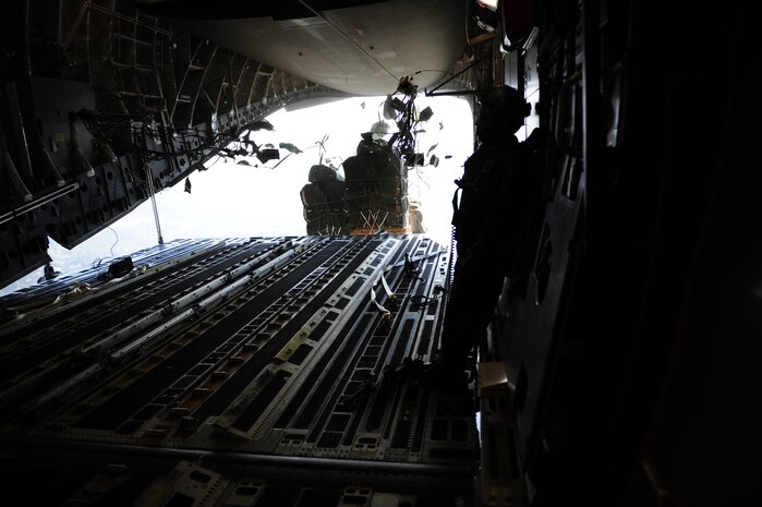 Container delivery system bundles exit a C-17 Globemaster III aircraft assigned to the 437th Airlift Wing, Charleston Air Force Base, S.C., during an air delivery mission over Haiti in support of Operation Unified Response Jan. 21, 2010. The aircrew, assigned to the 15th Airlift Squadron, Charleston AFB, S.C., delivered 40 container delivery system bundles totaling 67,800 pounds of Meals Ready to Eat and bottled water. (U.S. Air Force photo by Staff Sgt. Jacob N. Bailey / Released)