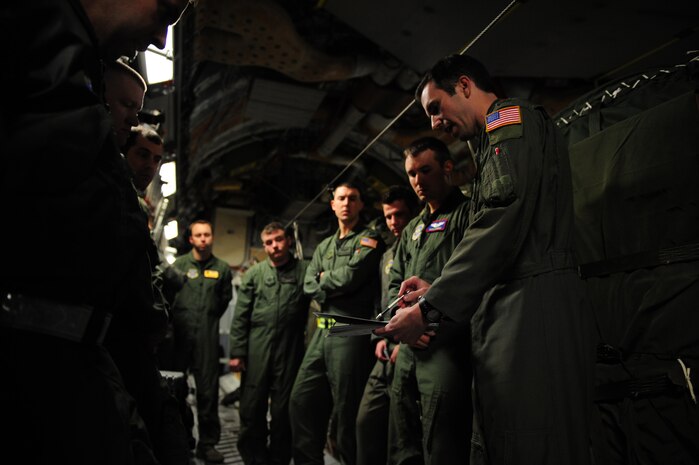 U.S. Air Force Maj. Jason Kirkland, right, a C-17 Globemaster III pilot assigned to the 15th Airlift Squadron, Charleston Air Force Base, S.C., briefs his fellow aircrew members prior to an air delivery mission in support of Operation Unified Response Jan. 21, 2010. The mission was the second air delivery flown to Haiti since relief operations began. (U.S. Air Force photo by Staff Sgt. Jacob N. Bailey / Released)