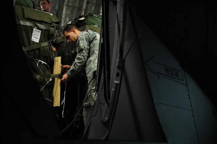 U.S. Army Spc. James Spath, 11th Quartermaster, 189th Combat Sustainment Support Brigade, Fort Bragg, N.C., checks the rigging of container delivery systems aboard a C-17 Globemaster III aircraft from the 437th Airlift Wing, Charleston Air Force Base, S.C., before an air delivery mission in support of Operation Unified Response Jan. 21, 2010. The aircrew, assigned to the 15th Airlift Squadron, Charleston AFB, S.C., delivered 40 container delivery system bundles totaling 67,800 pounds of Meals Ready to Eat and bottled water. (U.S. Air Force photo by Staff Sgt. Jacob N. Bailey/Released)