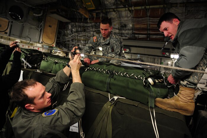 U.S. Air Force Staff Sgt. Richard Miner, left, a loadmaster assigned to the 43rd Operational Support Squadron, Pope Air Force Base, N.C., assists U.S. Army Specialists Jordan Markelwitz, right, and Daniel Rocco, 11th Quartermaster, 189th Combat Sustainment Support Brigade, Fort Bragg, N.C., with the load plan of a C-17 Globemaster III aircraft from the 437th Airlift Wing, Charleston Air Force Base, S.C., before an air delivery mission in support of Operation Unified Response Jan. 21, 2010. The aircrew, assigned to the 15th Airlift Squadron, Charleston AFB, S.C., delivered 40 container delivery system bundles totaling 67,800 pounds of Meals Ready to Eat and bottled water. (U.S. Air Force photo by Staff Sgt. Jacob N. Bailey / Released)