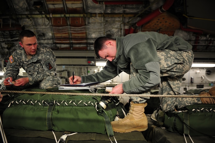 U.S. Army Specialists Jordan Markelwitz, right, and Daniel Rocco, 11th Quartermaster, 189th Combat Sustainment Support Brigade, Fort Bragg, N.C., review the load plan of a C-17 Globemaster III aircraft from the 437th Airlift Wing, Charleston Air Force Base, S.C., before an air delivery mission in support of Operation Unified Response Jan. 21, 2010. The aircrew, assigned to the 15th Airlift Squadron, Charleston AFB, S.C.,  delivered 40 container delivery system bundles totaling 67,800 pounds of Meals Ready to Eat and bottled water. (U.S. Air Force photo by Staff Sgt. Jacob N. Bailey / Released)