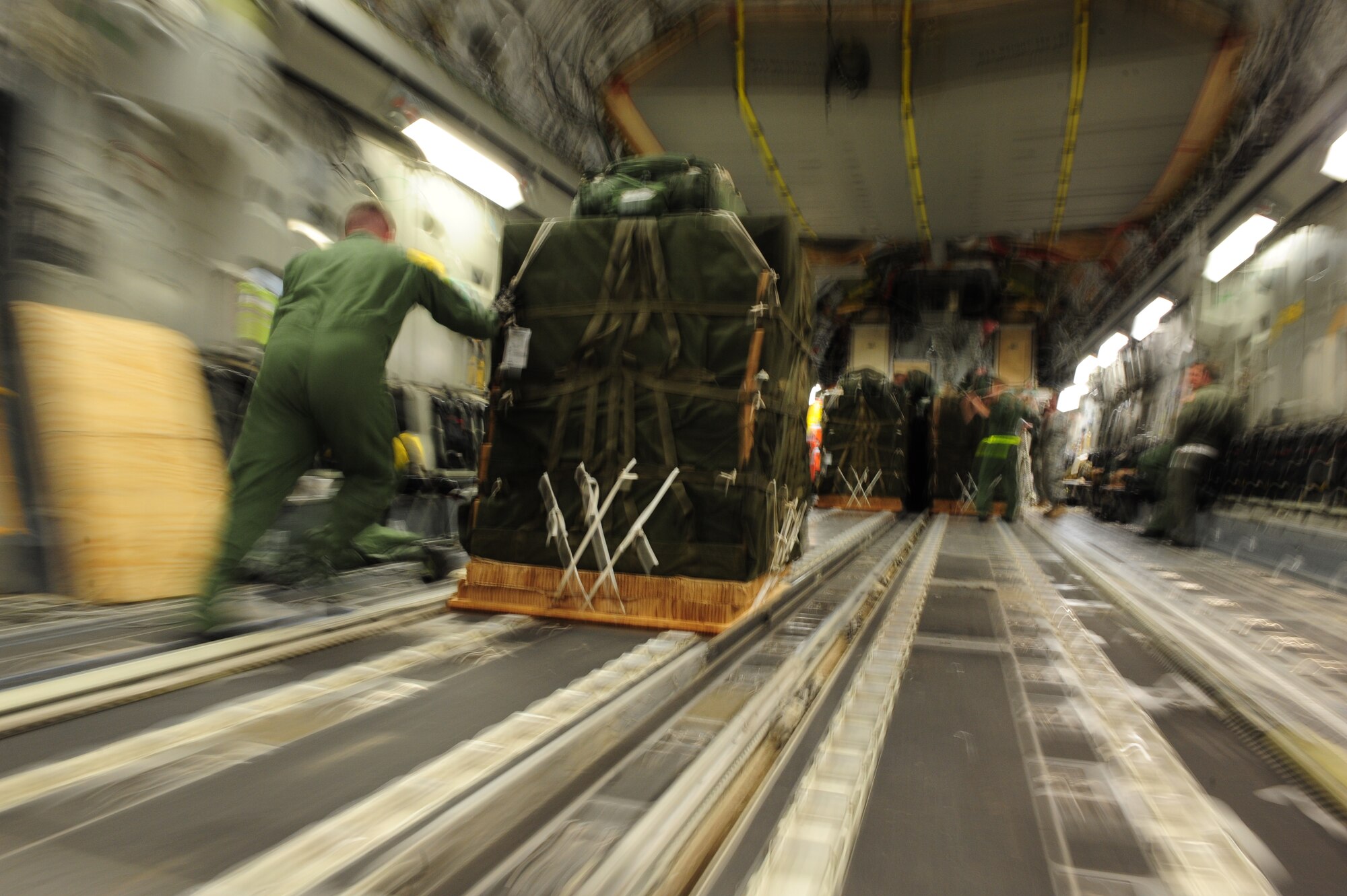 U.S. Air Force Staff Sgt. Matthew Shields, a C-17 Globemaster III loadmaster assigned to the 15th Airlift Squadron, Charleston Air Force Base, S.C., loads container delivery system bundles aboard a C-17 at Pope AFB, N.C., before an air delivery mission in support of Operation Unified Response Jan. 21, 2010. The crew delivered 40 container delivery system bundles totaling 67,800 pounds of Meals Ready to Eat and bottled water. (U.S. Air Force photo by Staff Sgt. Jacob N. Bailey / Released)