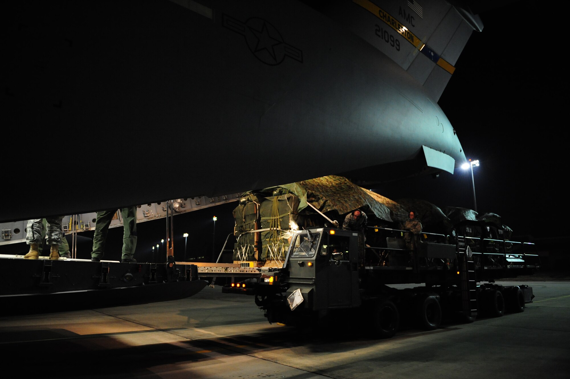 U.S. Air Force Airman assigned to the 43rd Logistical Readiness Squadron, Pope Air Force Base, N.C., load a C-17 Globemaster III  from the 437th Airlift Wing, Charleston Air Force Base, S.C., before an air delivery mission in support of Operation Unified Response Jan. 21, 2010. The crew loaded 40 container delivery system bundles totaling 67,800 pounds of Meals Ready to Eat and bottled water. (U.S. Air Force photo by Staff Sgt. Jacob N. Bailey / Released)