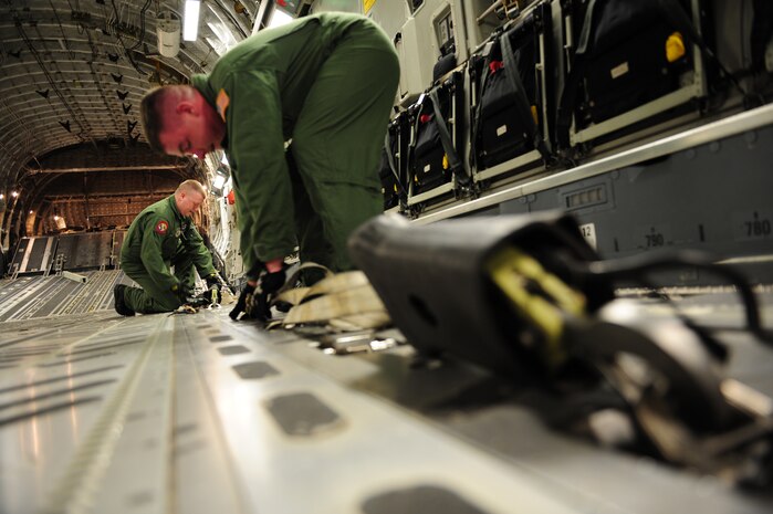 U.S. Air Force Senior Airman Mike Solly, left, and Staff Sgt. Matthew Shields, C-17 Globemaster III loadmasters assigned to the 15th Airlift Squadron, Charleston Air Force Base, S.C., adjust an aircraft configuration before an air delivery mission in support of Operation Unified Response at Charleston AFB Jan. 20, 2010. The mission was the second air delivery flown to Haiti since relief operations began. (U.S. Air Force photo by Staff Sgt. Jacob N. Bailey / Released)
