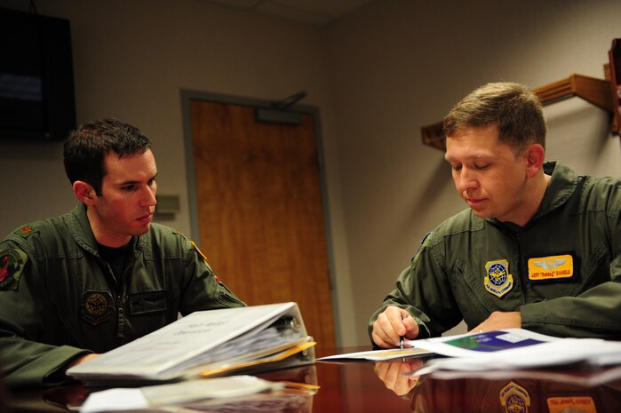 U.S. Air Force Majors Jeff Daniels, right, and Jason Kirkland, C-17 Globemaster III pilots assigned to the 437th Operations Group, Charleston Air Force Base, S.C., review a flight plan prior to an air delivery mission in support of Operation Unified Response, Jan. 20, 2010. (U.S. Air Force photo by Staff Sgt. Jacob N. Bailey / Released)