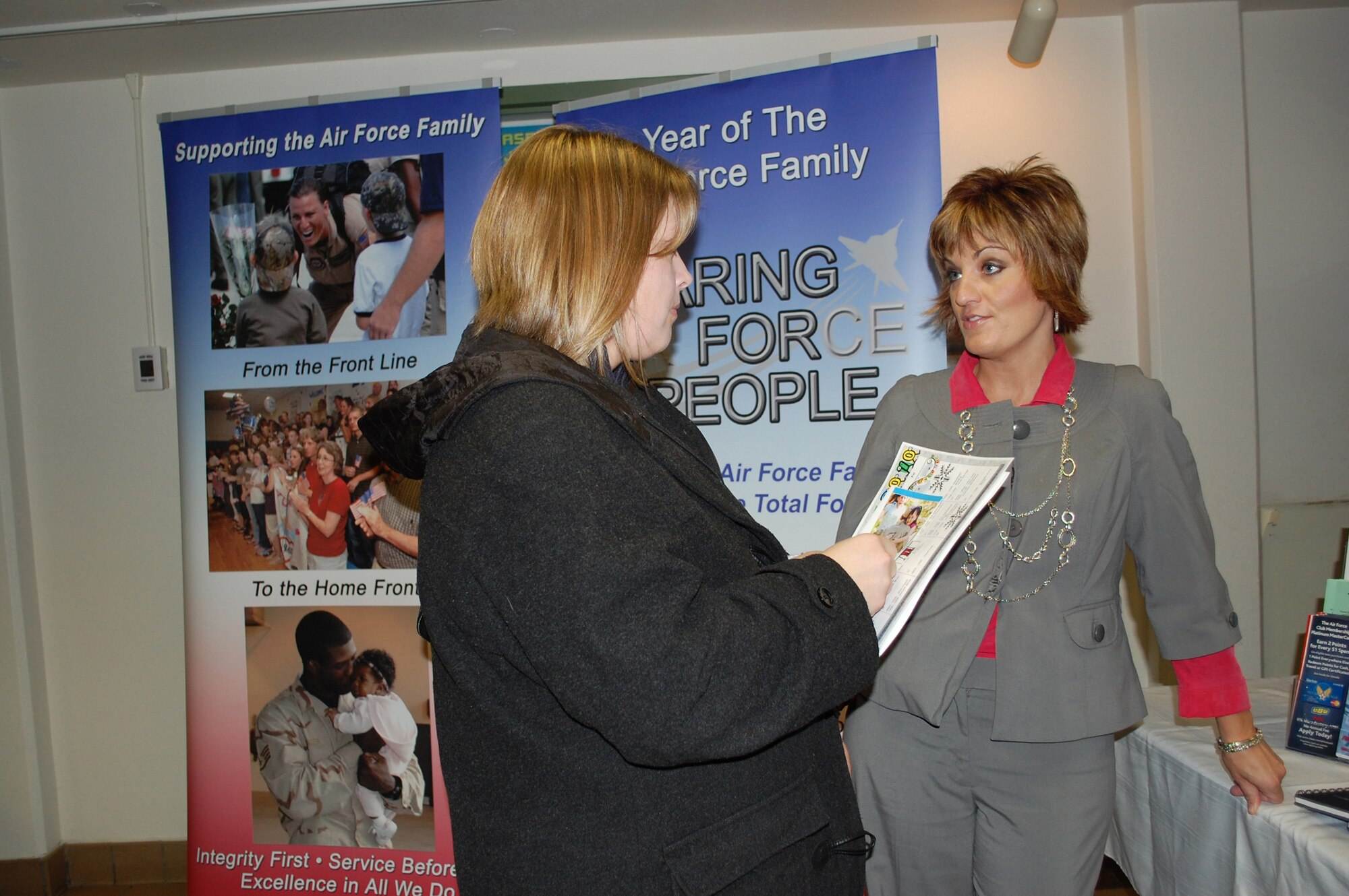 Staci Corder, right, 341st Force Support Squadron marketing director, talks with Malmstrom spouse Tina Penny, about Year of the Air Force Family initiatives and upcoming events prior to the start of the  Spouse's Call briefing at the base theater Jan. 14. (U.S. Air Force photo/Valerie Mullett)