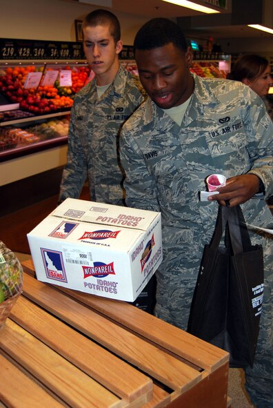 Airman 1st Class Justen Davis, a 341st Civil Engineering Squadron operations manager, picks up a box of Idaho potatoes to estimate its weight to win a prize at the nutritional informational session at the commissary Jan. 13. (U.S. Air Force photo/Airman 1st Class Kristina Overton)