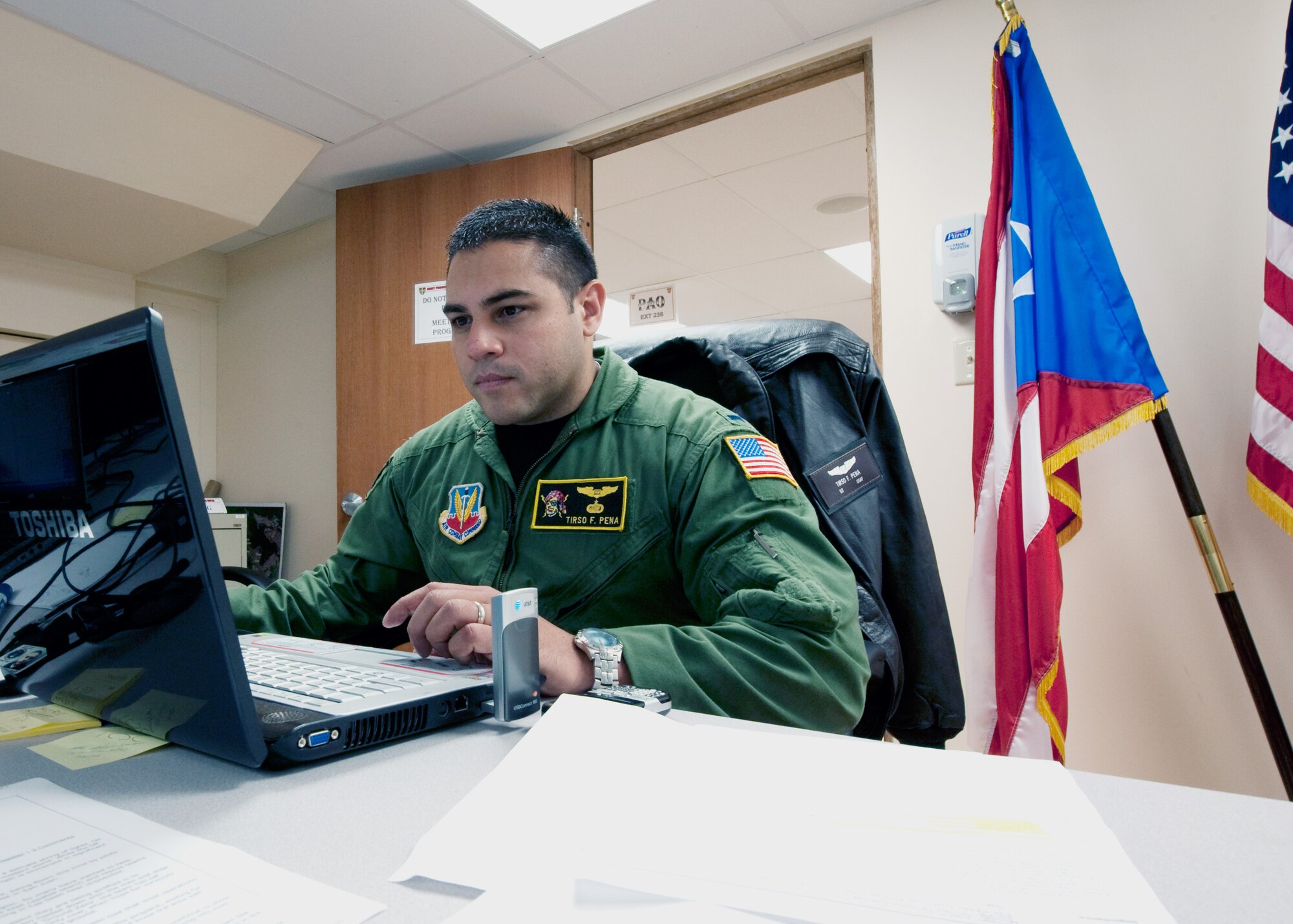 1st Lt. Tirso Peña, a navigator assigned to the Puerto Rico Air National Guard's 156th Airlift Squadron, monitor a chat room at the Puerto Rico National Guard joint operations center in San Juan, P.R. Multiple military units use the chat room to transmit information about the Haitian earthquake relief efforts. Peña said the JOC is relaying this information to Army aviation units on the ground in the Dominican Republic. (U.S. Air Force photo/Staff Sgt. Paul Croxon)